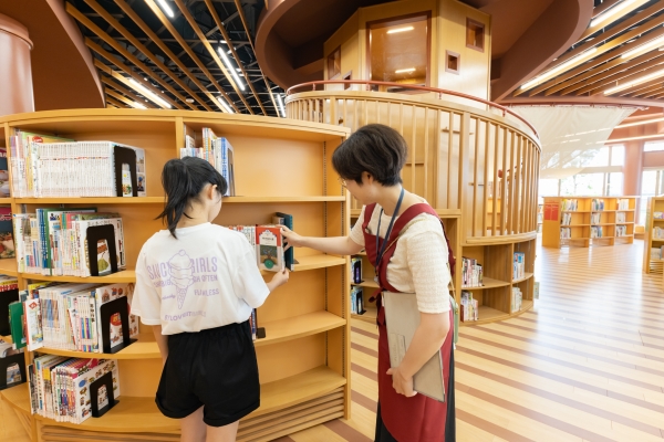 図書館の職員が調べもののお手伝いをしている写真